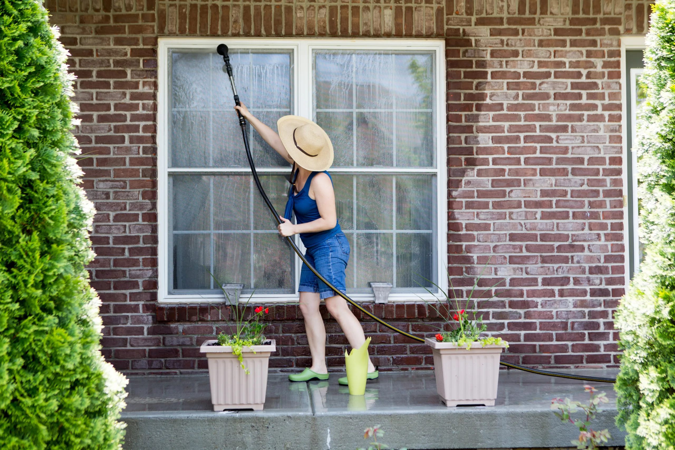 Mujer haciendo la limpieza de primavera y lavando las ventanas