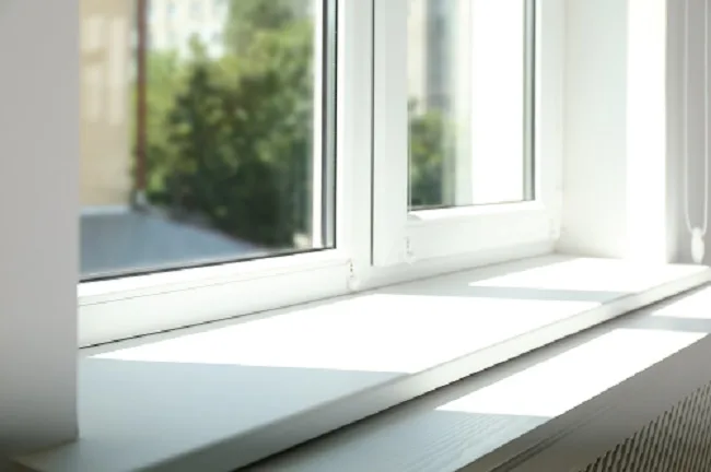 White framed vinyl window with a window sill.