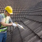 Roofer Sealing Roof Tiles with a silicon Sealant