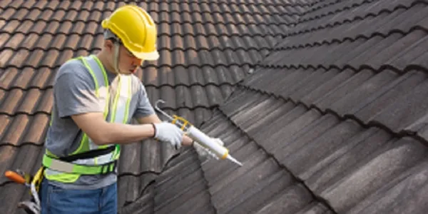 Roofer Sealing Roof Tiles with a silicon Sealant