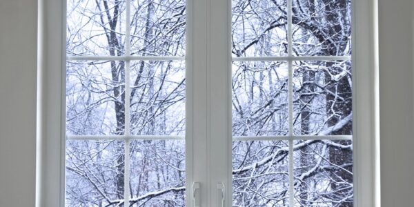 Residential home window with the outside being covered in snow.